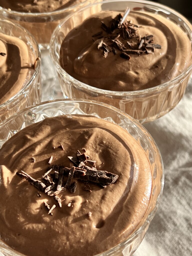 Krämig chokladmousse i glas med riven choklad på toppen.